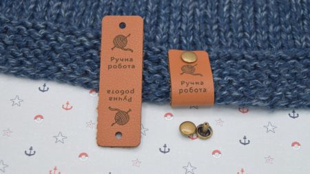 Шкіряна нашивка на кнопці, бірочка з написом Ручна робота і моток пряжи, колір Коричневий , 60х20мм, 1 шт