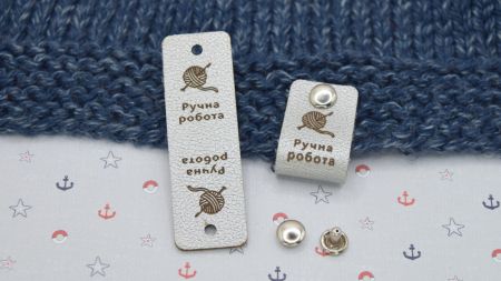 Шкіряна нашивка на кнопці, бірочка з написом Ручна робота і моток пряжи, колір Срібний , 60х20мм, 1 шт