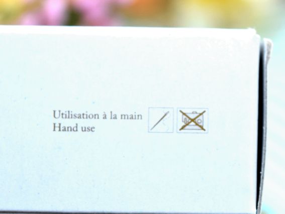 Фрагмент білої упаковки з текстовим попередженням «Utilisation à la main / Hand use» та значками, які дозволяють ручне шиття й забороняють використання у швейній машинці.