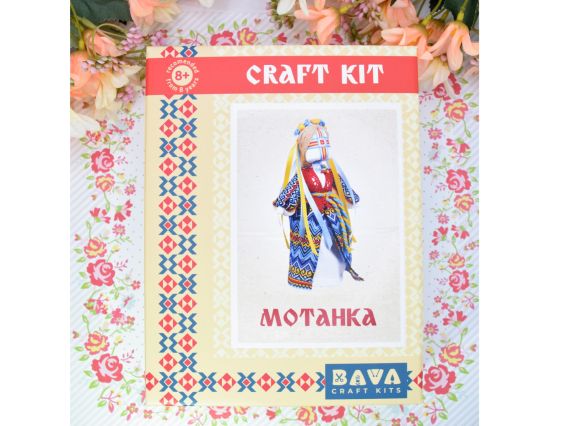Лицьова сторона коробки набору для створення ляльки-мотанки «Незалежна» від бренду BAVA, прикрашена традиційним червоно-чорним українським візерунком та квітами по краях.