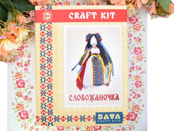 Лицьова сторона коробки набору для створення ляльки-мотанки від бренду BAVA, прикрашена традиційним українським геометричним візером червоно-чорного кольору.