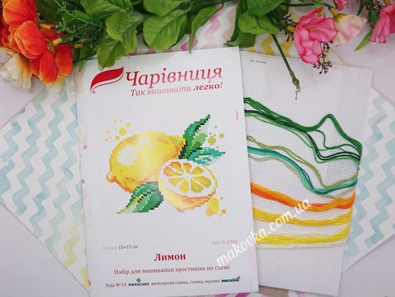 Обкладинка набору для вишивання «Лимон» (N-1701) ТМ «Чарівниця» поруч із білою канвою та яскравими нитками муліне жовтих і зелених кольорів.