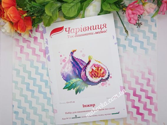 Це обкладинка набору для вишивання «Інжир» від бренду «Чарівниця» з акварельною ілюстрацією плодів. На упаковці вказано назву серії та логотип виробника на фоні декоративних квітів.