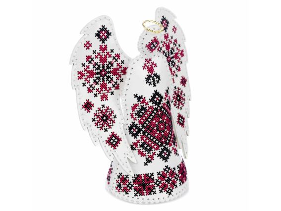 Вигляд у півоборота (справа) об'ємної фігурки янгола ручної роботи. Демонструє, як традиційні народні візерунки розташовані на тулубі та крилах з екошкіри.