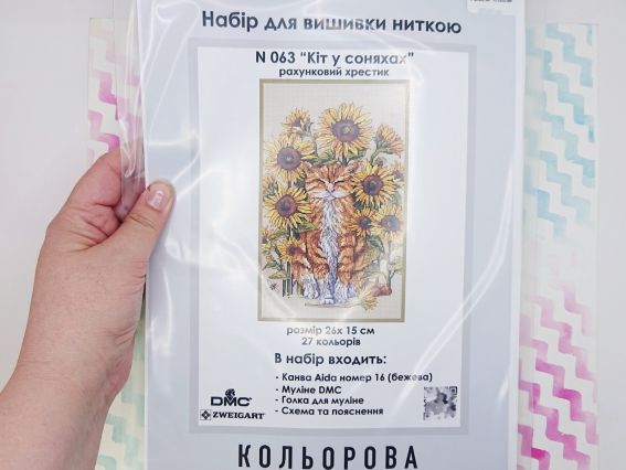 Упаковка набору для вишивання нитками Кольорова N 063 Кіт у соняхах у руках покупця.